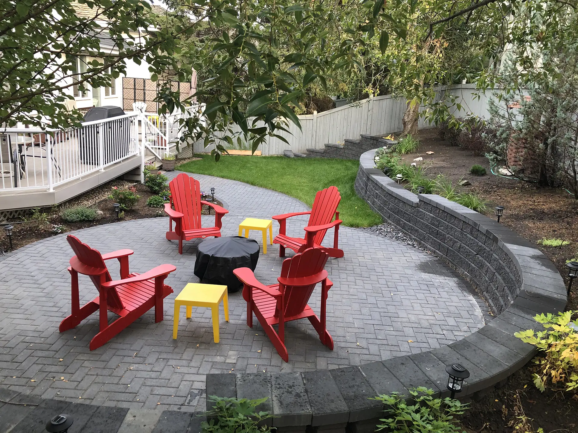 Curved retaining wall with circular paving stone patio in Riverbend Edmonton